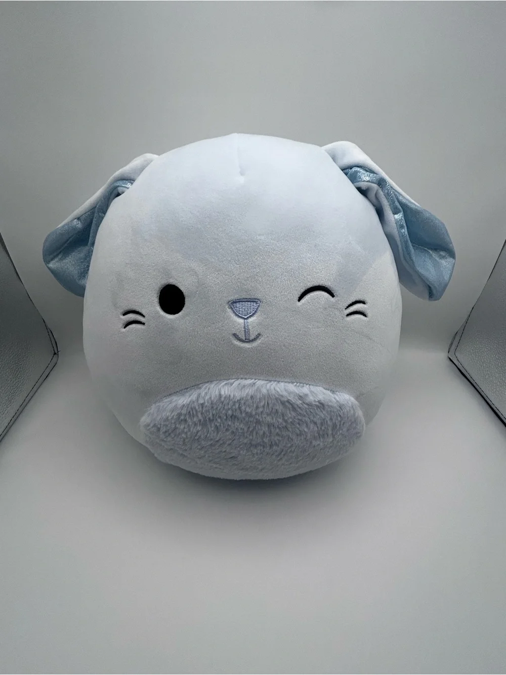 Squishmallows light blue plush with rainbow logo tag